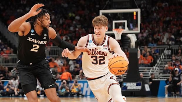 La guardia dell'Illinois Kasparas Jakucionis (32) guida verso il cestino contro l'attaccante di Xavier Jerome Hunter (2) nel torneo NCAA.